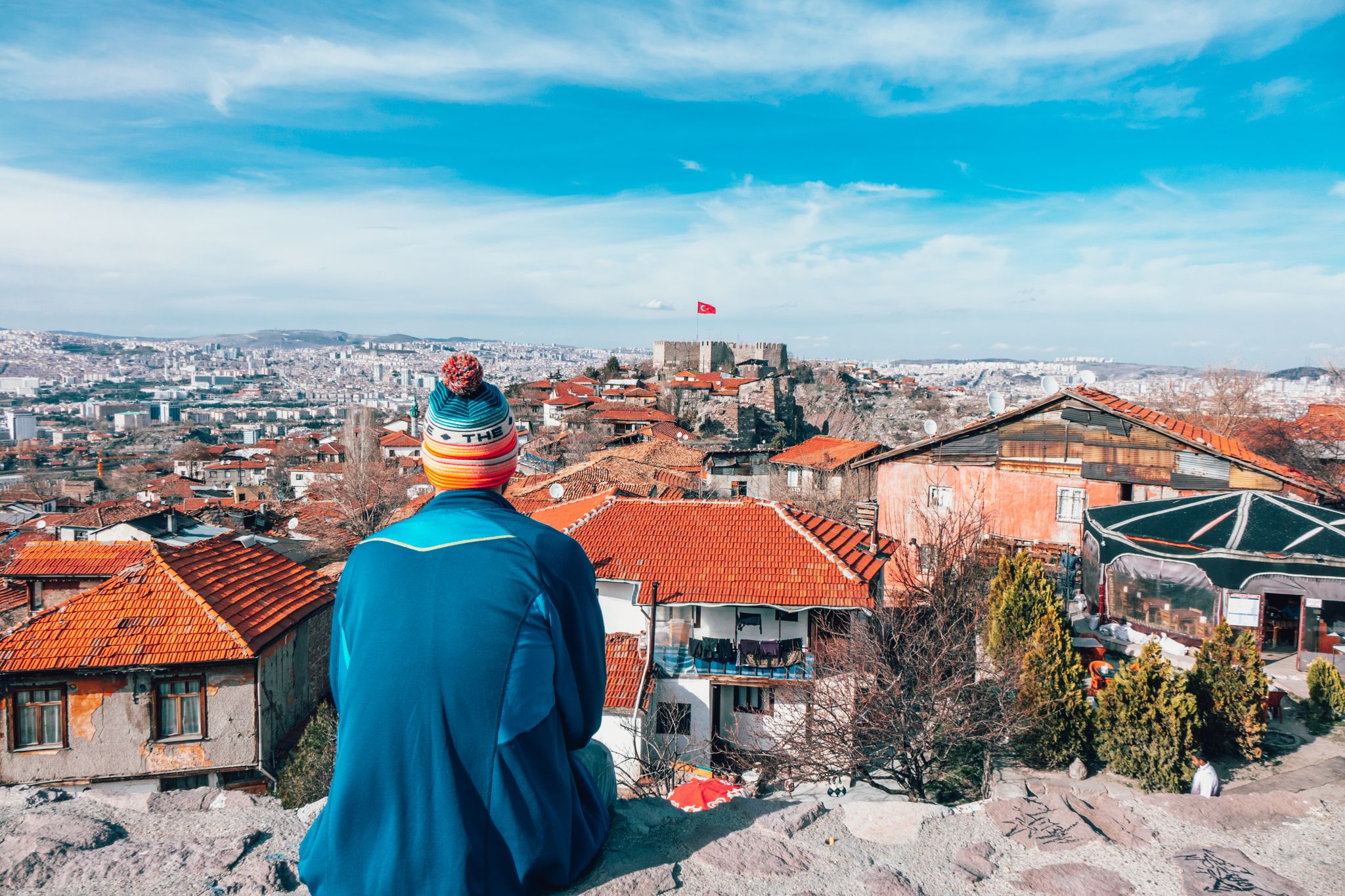 photo of men sitting on the wall looking at Ankara Castle in Altındağ, Ankara, Turkey.