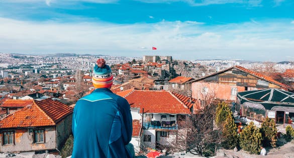 photo of men sitting on the wall looking at Ankara Castle in Altındağ, Ankara, Turkey.