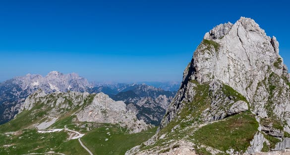Photo of Scenic view of high alpine Mangart road (Mangartska cesta) seen from Mangart Saddle (Mangartsko sedlo) in untamed Julian Alps, border Slovenia Italy, Europe.