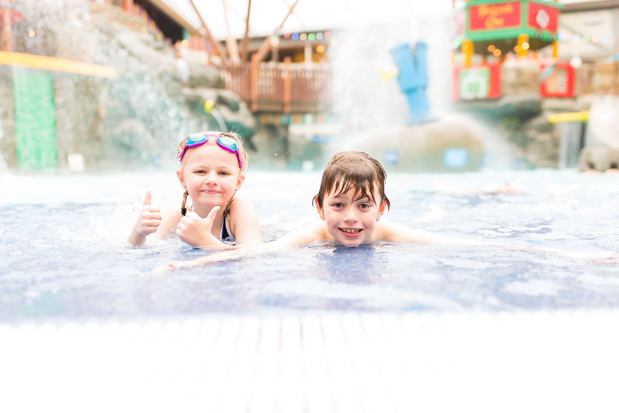 Cute little boy and girl having fun in the swimming pool, Alton towers water park, Cariba Creek