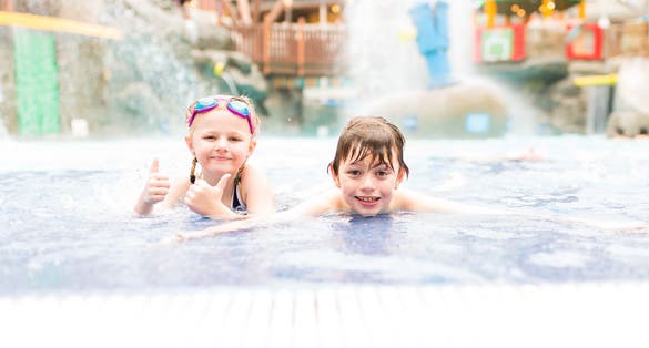 Cute little boy and girl having fun in the swimming pool, Alton towers water park, Cariba Creek