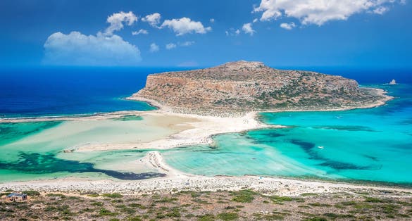 photo of view of Balos lagoon on Crete island, Greece. Tourists relax and bath in crystal clear water of Balos beach.,vMunicipality of Kissamos, Greece.