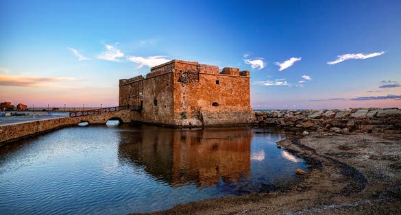 Photo of the castle of Paphos early in the morning with reflection on the water.