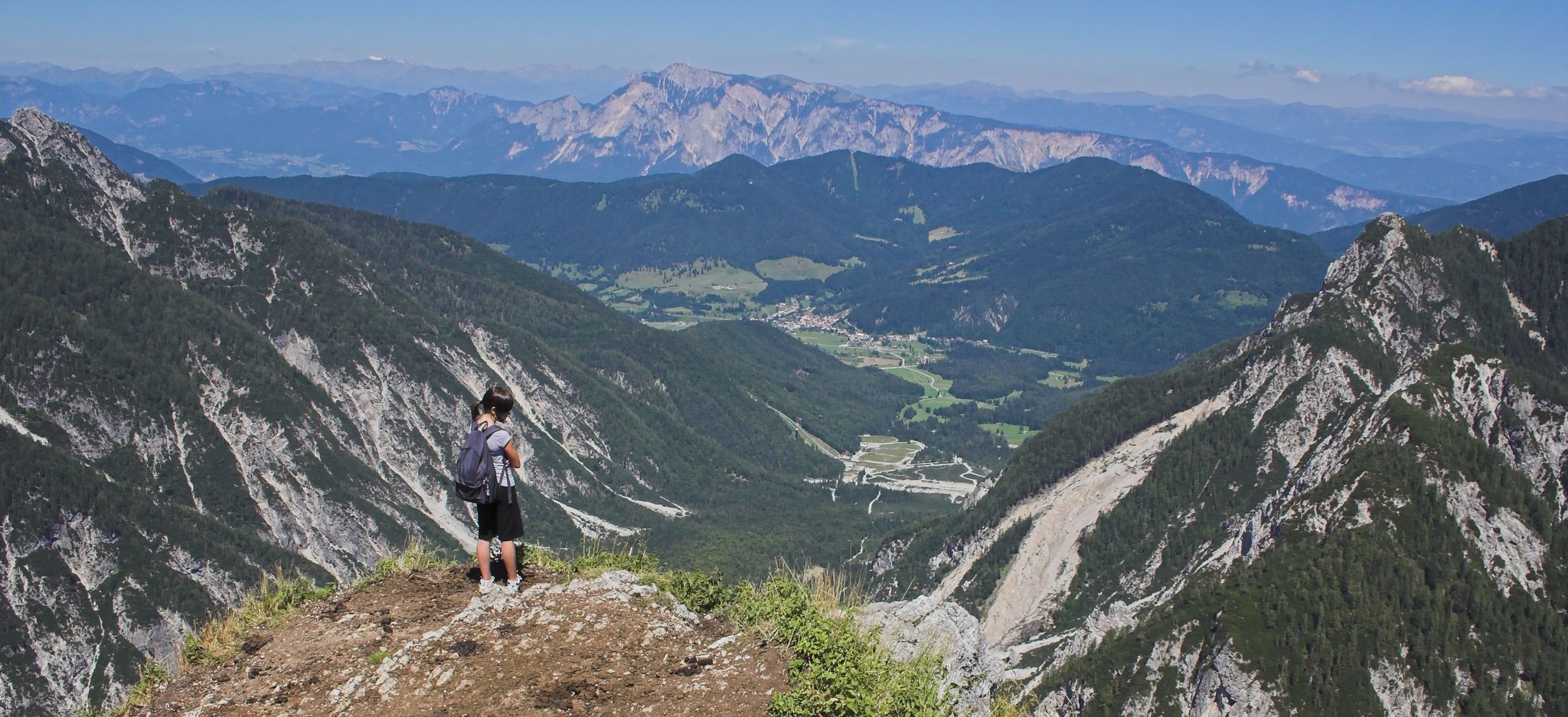 young girl on the top of a mountain, In the center is the giant ski-jump Planica (world's biggest with flight records over 230m); border triangle
