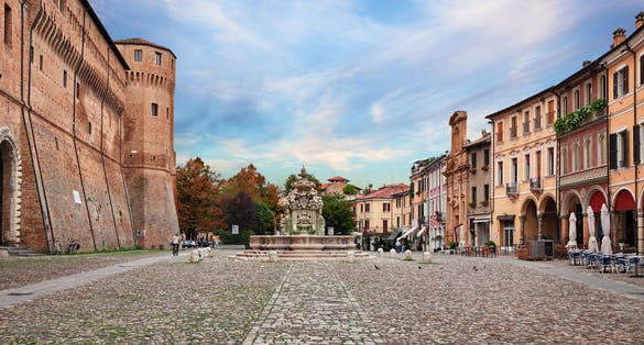 Photo of landscape of the ancient square Piazza del Popolo with the fortified palace Rocchetta di Piazza and the fountain Fontana del Masini in the old town of the city Cesena, Emilia-Romagna, Italy.