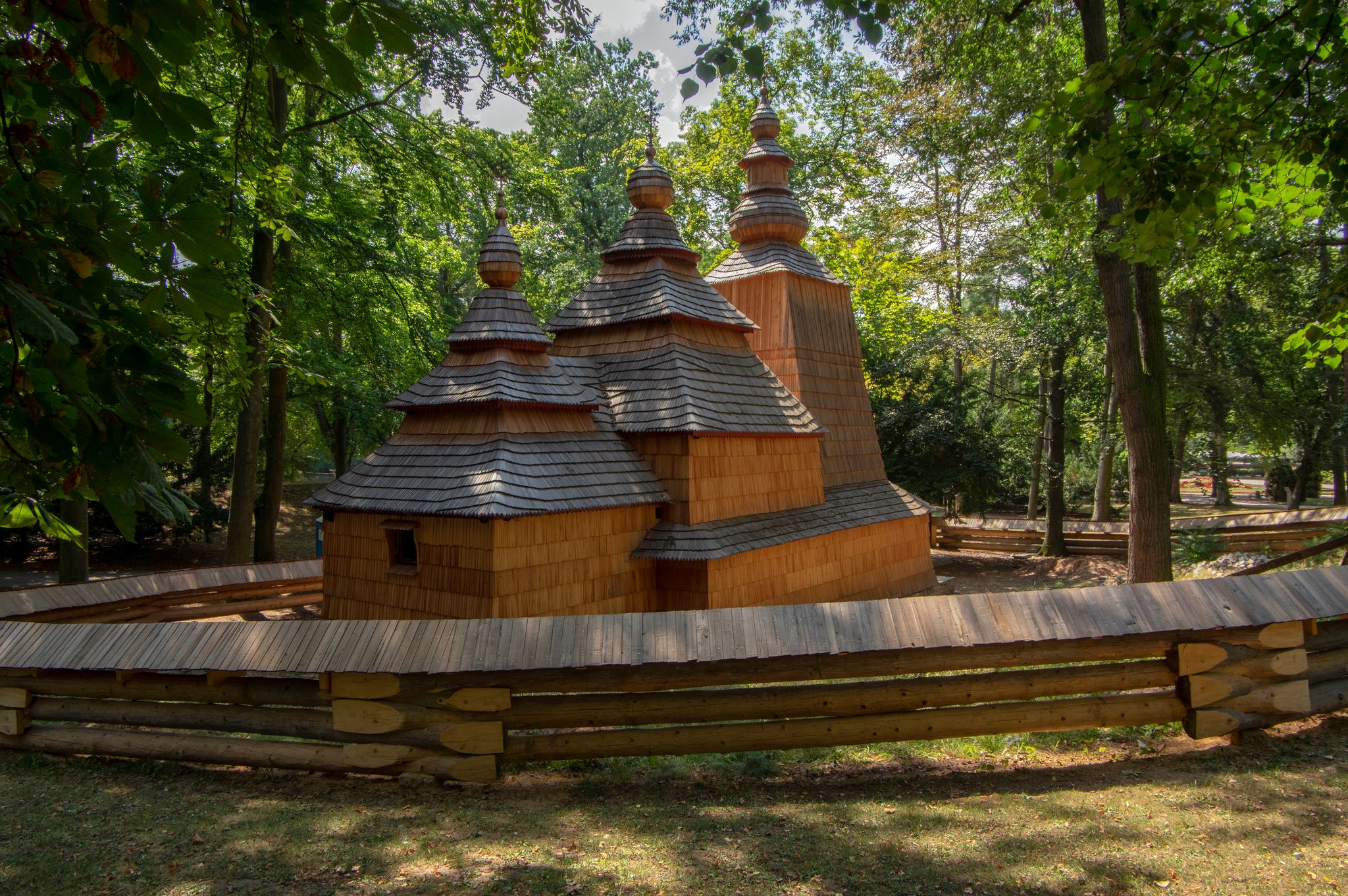 Photo of Wooden temple Church of St. Nicholas originally from Slovak village Habura in Hradec Kralove gardens, old historic building during summer.