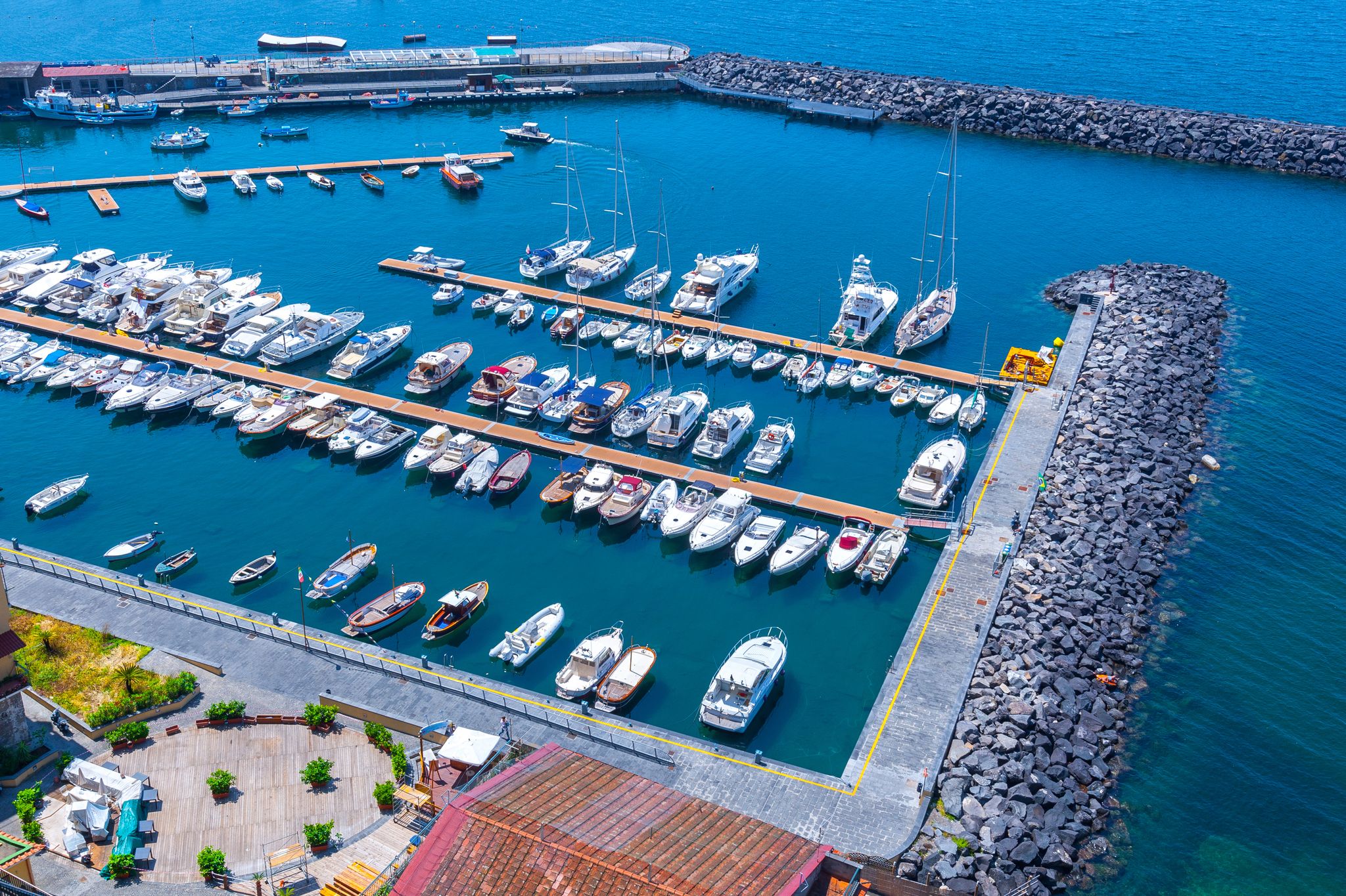 photo of aerial panorama of high cliffs, Tyrrhenian Sea Bay with pure azure water, floating boats and ships, pebble beaches, rocky surroundings of Meta in Sant'Agnello and Sorrento cities near Naples region in Italy.