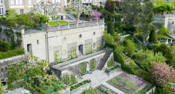 photo of romantic green terraced gardens in spring on the slope near the old city wall of Bern, as seen from the viewing platform Münster in Bern, Switzerland.