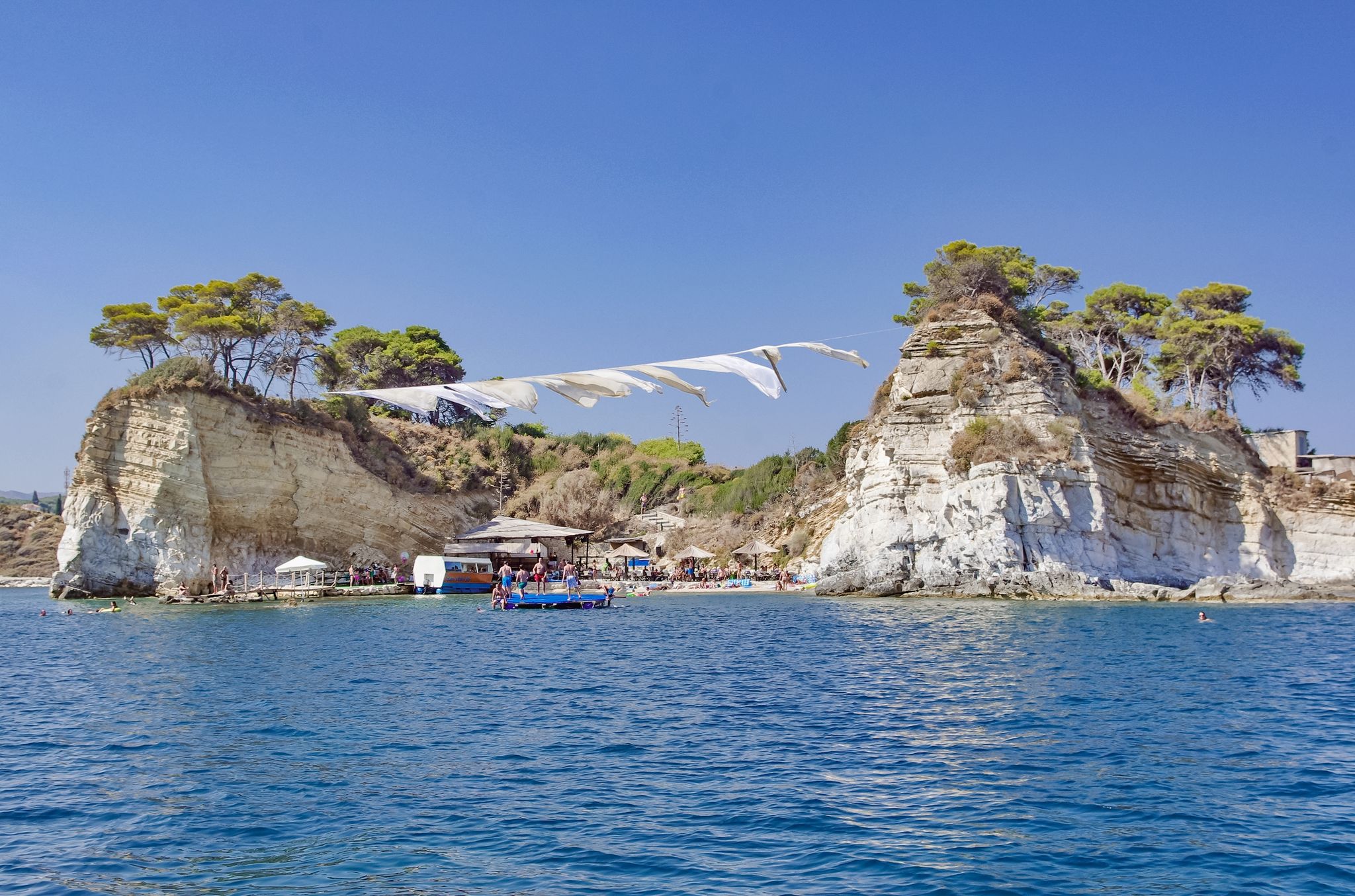 photo of view of Excursion and boat cruise on the Ionian Sea, Cameo island in Zakynthos. wooden pot and ropes between the shore and the island Cameo - beach party island in Greece,Laganas Greece.