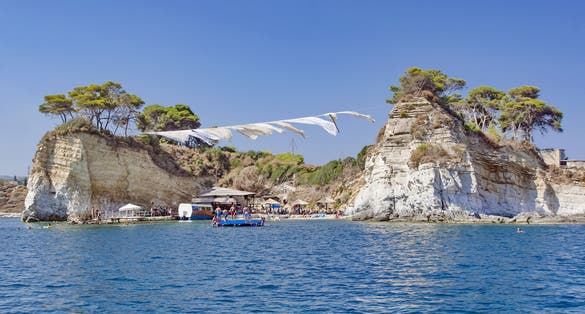 photo of view of Excursion and boat cruise on the Ionian Sea, Cameo island in Zakynthos. wooden pot and ropes between the shore and the island Cameo - beach party island in Greece,Laganas Greece.
