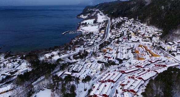 photo of view of Molde, Norway. Aerial view of residential area in Molde, Norway during a cloudy day in winter. Beautiful fjord with mountains covered in snow