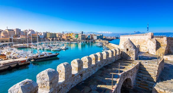 Photo of Heraklion harbour with old venetian fort Koule and shipyards, Crete, Greece.