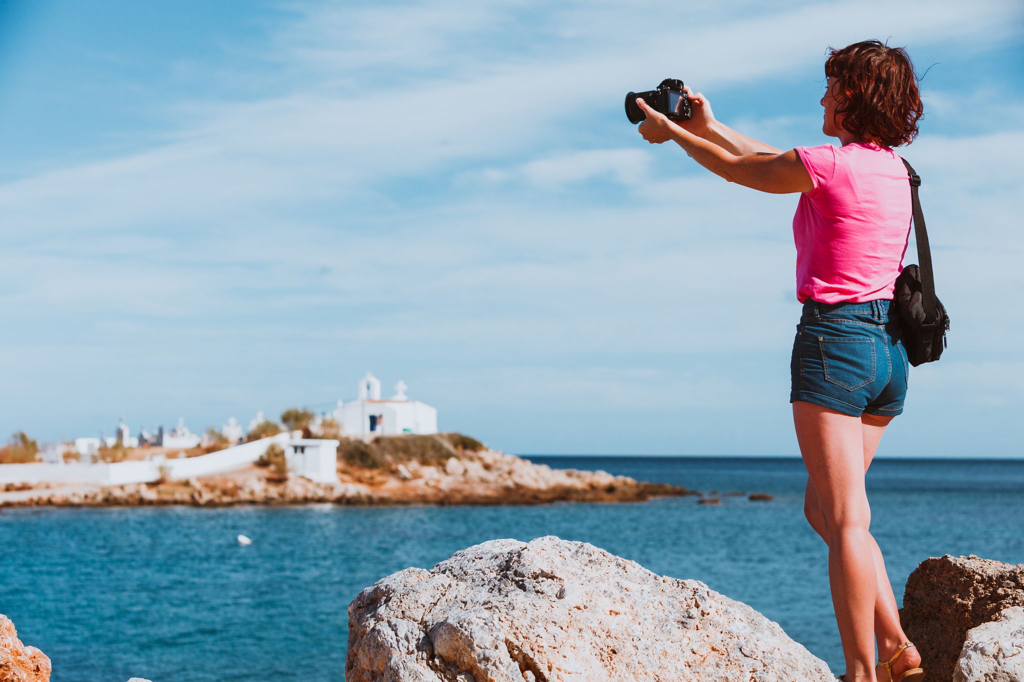 photo of view ofTourism vacation and travel. Woman tourist on sea shore taking photo with camera, Agios Fokas near Monemvasia, Laconia region Peloponnese.,Parikia greece.