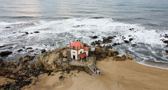 Aerial drone view over the Chapel of Senhor da Pedra at Miramar beach, Gulpilhares, Vila Nova de Gaia - Portugal