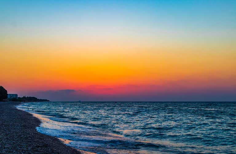Photo of rainbow colors of the most beautiful sunset at Ialysos Beach on Rhodes Island Greece.