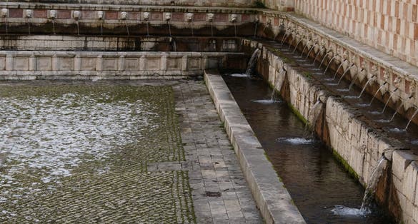 Fountain of the 99 Spouts (Fontana delle 99 cannelle), Historic fountain with 99 jets distribuited along three walls, L Aquila, Italy.