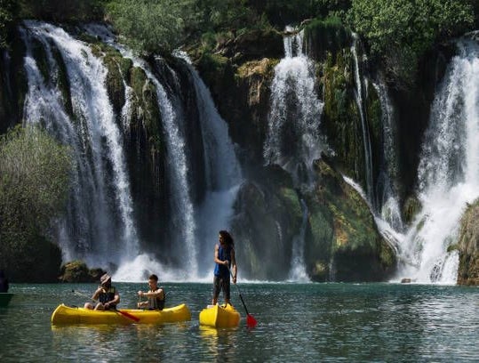 People kayaking in the clear waters near Kravica Waterfall in Bosnia and Herzegovina.jpg