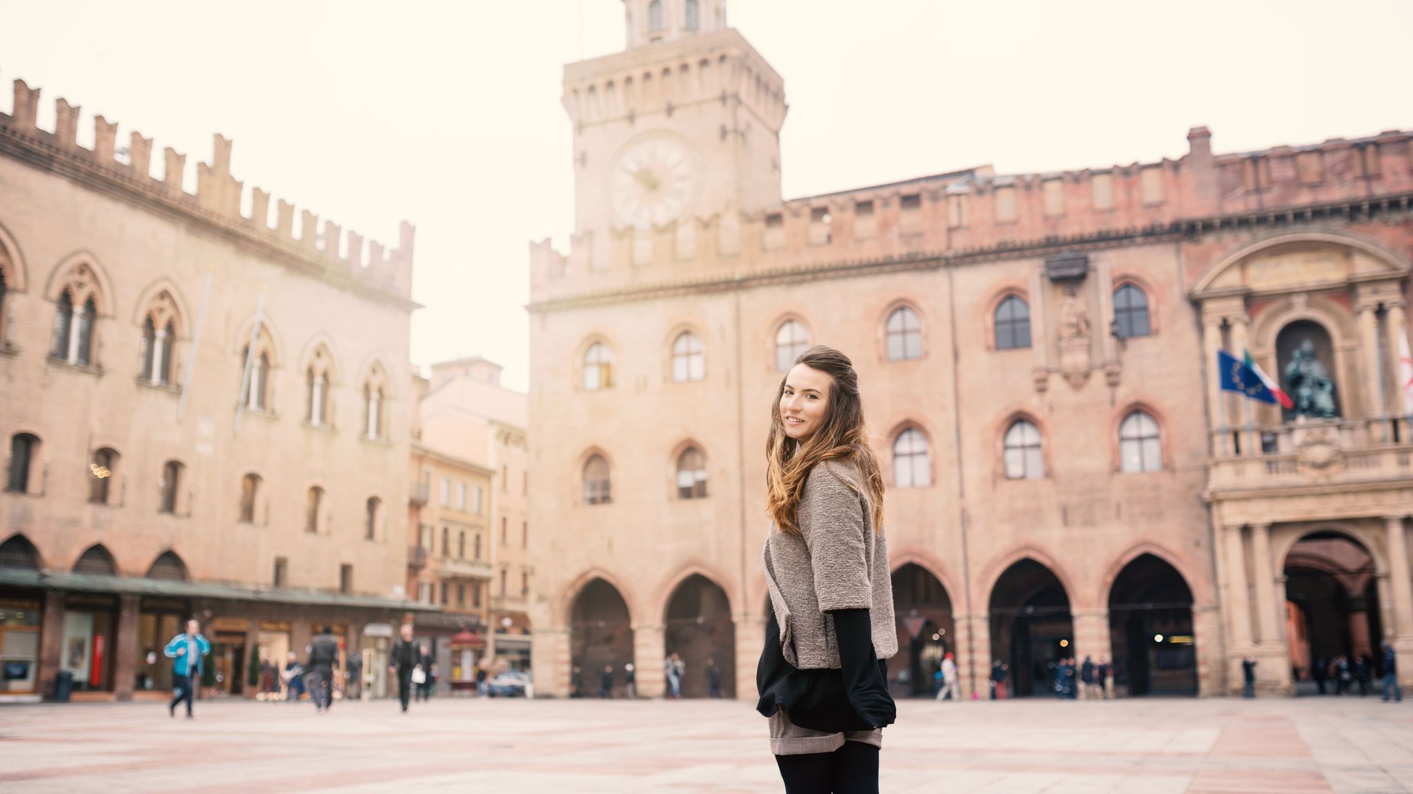 photo of happy beautiful woman portrait outdoors in piazza maggire, Bologna, Italy. Natual flare.