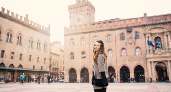 photo of happy beautiful woman portrait outdoors in piazza maggire, Bologna, Italy. Natual flare.
