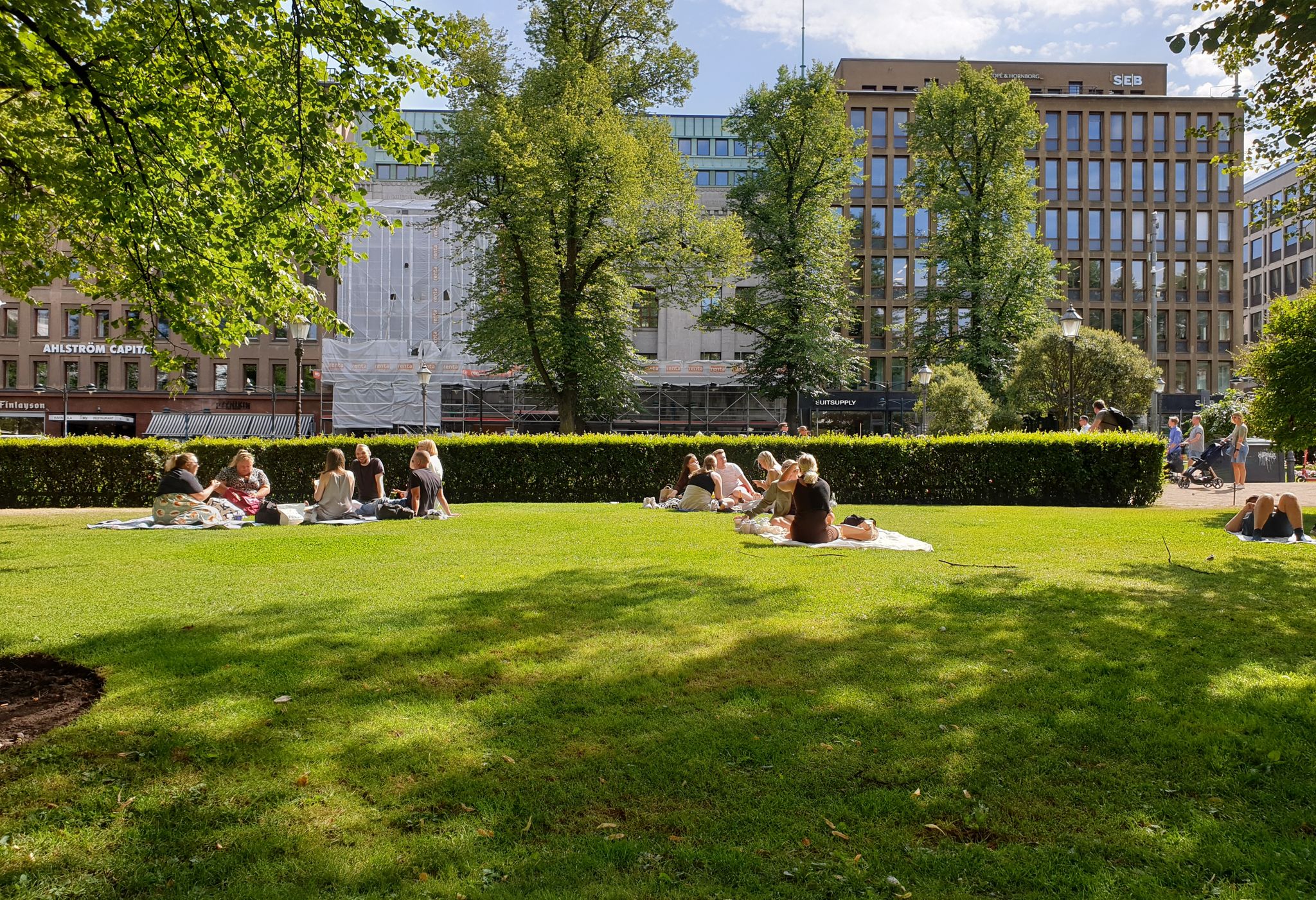 Photo of People are enjoying a sunny summer day having a picnic in the Esplanadi park.