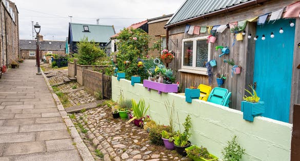 Photo of Fishermen's houses with brightly coloured plants and decorations in the Footdee Sweep, Aberdeen, Scotland.