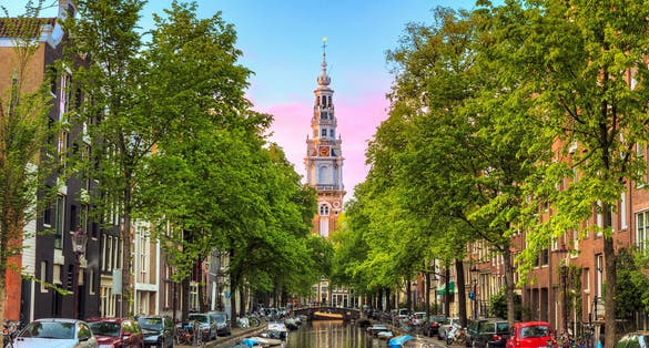 Beautiful Groenburgwal canal in Amsterdam with the Soutern church (Zuiderkerk) at sunset in summer.