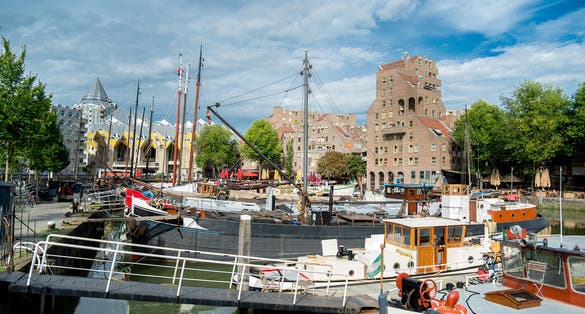 Rotterdam Holland - September 26th 2023: Yacht and boat seaport in Rotterdam centrum. Old harbor Cubehouses behind