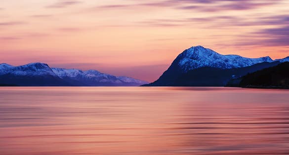 photo of view of Molde, Norway. Beautiful fjord in Norway at sunset. View of the mountains in Molde, Norway in the evening. Fjord with sea in summer, cloudy motion blurred sky and waves