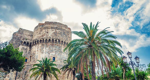 Aragonese Castle Castello Aragonese stone medieval buildings and palm trees in Piazza castello square in Reggio Calabria.