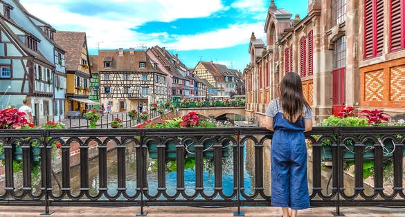 Photo of Asian girl admires the urban landscape of Colmar, France.