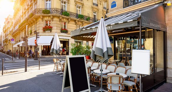 Typical view of the Parisian street with tables of brasserie (cafe) in Paris, France.