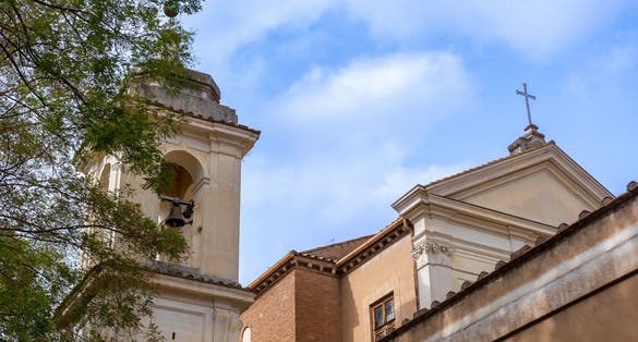 photo of Side View with the Bell Tower of the Basilica of San Clemente in the Center of Rome on a Background of Partly Cloudy Sky,Rome Italy.