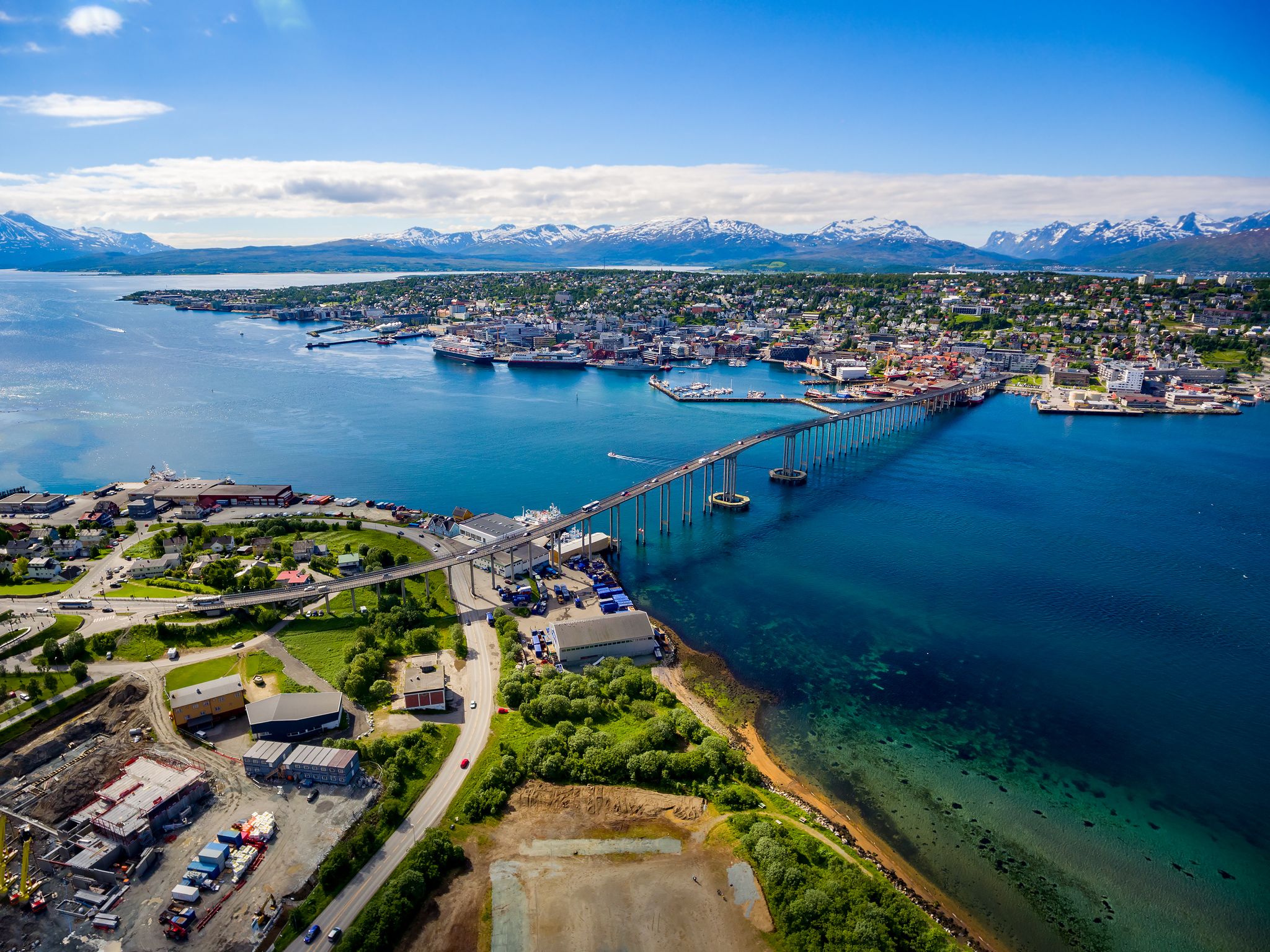 Photo of houses, bridge and panorama of Norwegian city Tromso beyond the Arctic circle from mountain in Norwegian fjords.