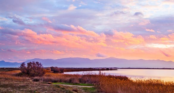Photo of cloudy winter sunset at "Etang de Canet-Saint Nazaire" lake, Perpignan city, France.