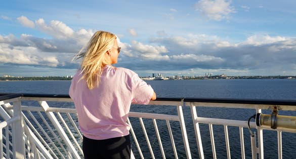 Photo of a tourist on the deck of a ship sailing from Tallinn, Estonia.