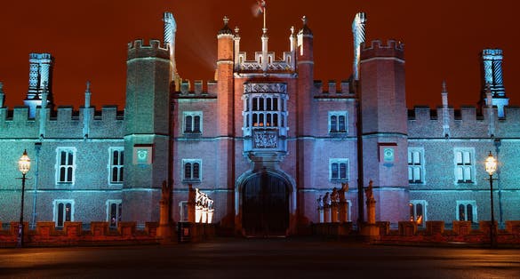Photo of Hampton Court Palace illuminated at night, England.