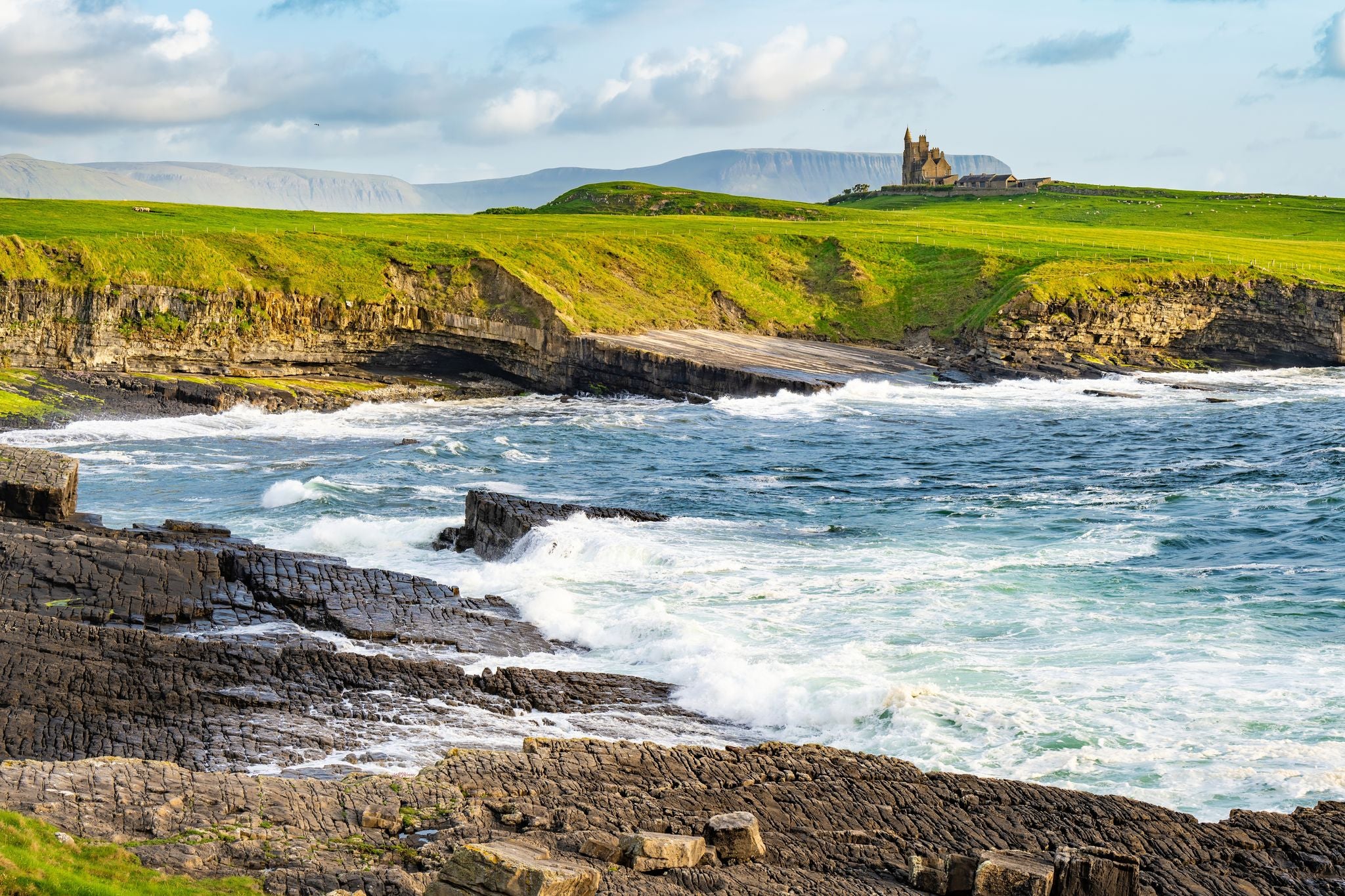 photo of view of Famous Classiebawn Castle in picturesque landscape of Mullaghmore Head. Spectacular sunset view with huge waves rolling ashore. Signature point of Wild Atlantic Way, Co. Sligo, Ireland