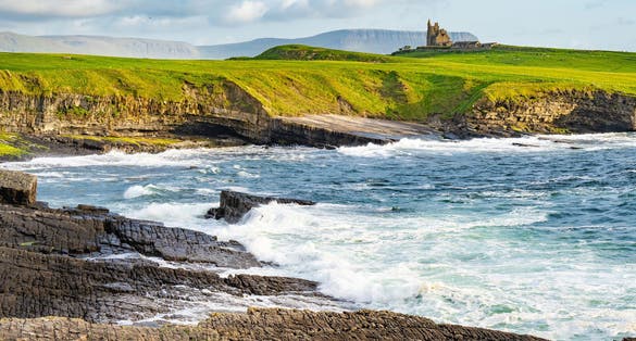 photo of view of Famous Classiebawn Castle in picturesque landscape of Mullaghmore Head. Spectacular sunset view with huge waves rolling ashore. Signature point of Wild Atlantic Way, Co. Sligo, Ireland