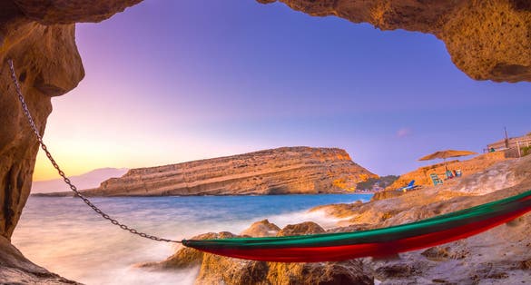photo of view of Matala beach with caves on the rocks that were used as a roman cemetery and at the decade of 70's were living hippies from all over the world, Crete, Greece,Mátala Greece.