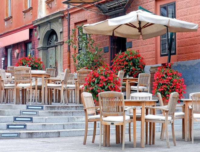 Empty outdoor café with wooden tables and red flowers on a quiet street in Slovenia..jpg