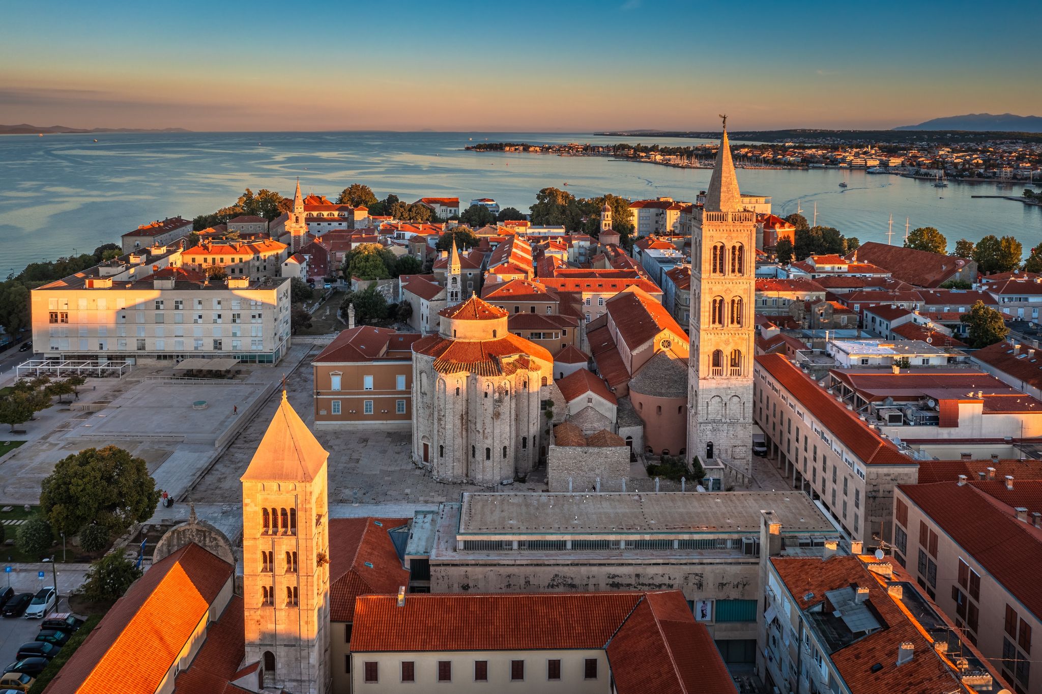Photo of aerial view of the old town of Zadar by the Adriatic sea with Church of St. Donatus and the Cathedral of St. Anastasia and blue sky on a bright summer morning.