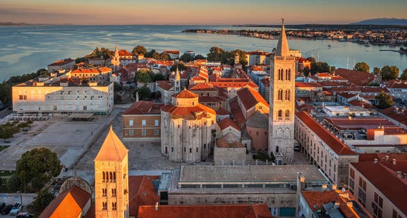 Photo of aerial view of the old town of Zadar by the Adriatic sea with Church of St. Donatus and the Cathedral of St. Anastasia and blue sky on a bright summer morning.