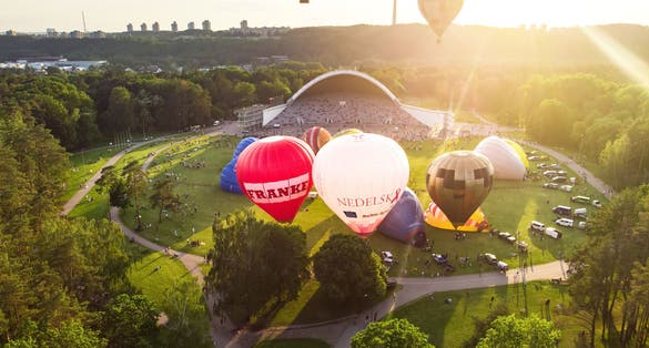 photo of Vilnius ,Lithuania - JULY 3, 2020: Colorful hot air balloons taking off in vingis park in Vilnius city on sunny summer evening. Lots of people watching as balloons fly away.