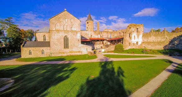 Photo of the old ruined Haapsalu castle in Estonia. It has a green grassland outside the ruined castle.