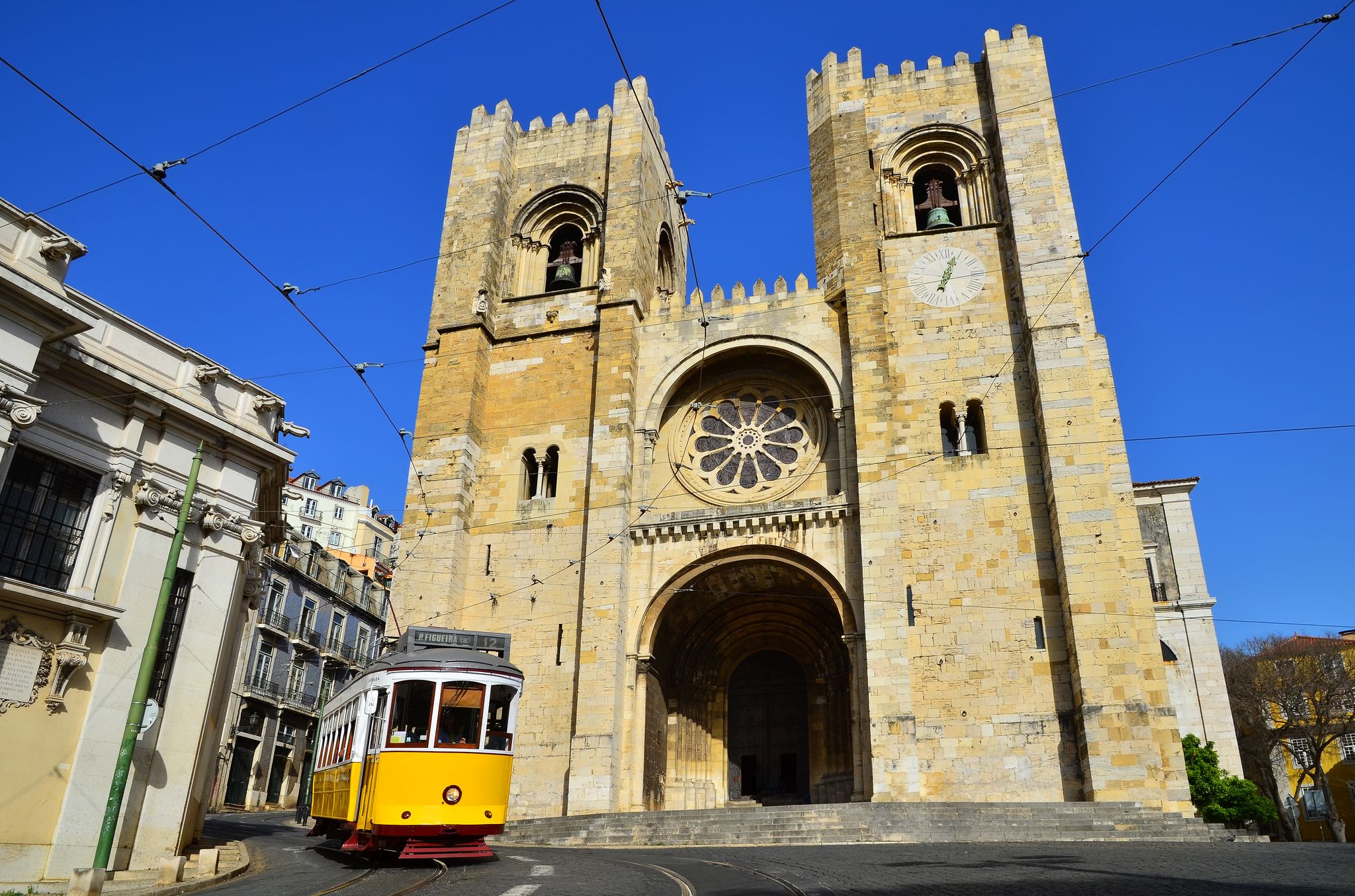 Photo of Se Cathedral (oldest church, from XIIth century) and Yellow Tram (Americanos), two symbols of Lisbon, Portugal.