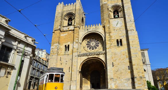 Photo of Se Cathedral (oldest church, from XIIth century) and Yellow Tram (Americanos), two symbols of Lisbon, Portugal.
