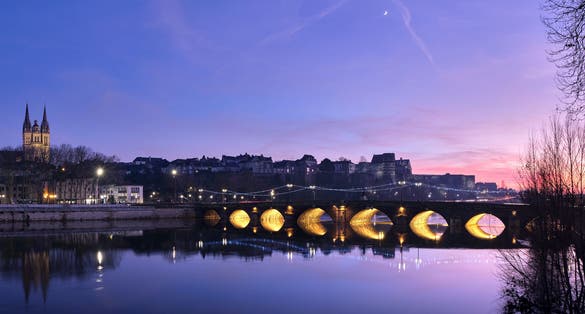 photo of  view of Skyline of Angers by night, city of France, with the cathedral, the castle, and a bridge, during the sunset with a beautiful colorfull sky