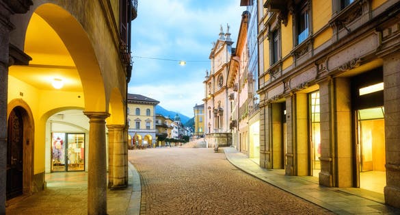 Photo of Central pedestrian street and main square in Bellinzona city's Old town in the evening light, Ticino, Switzerland.