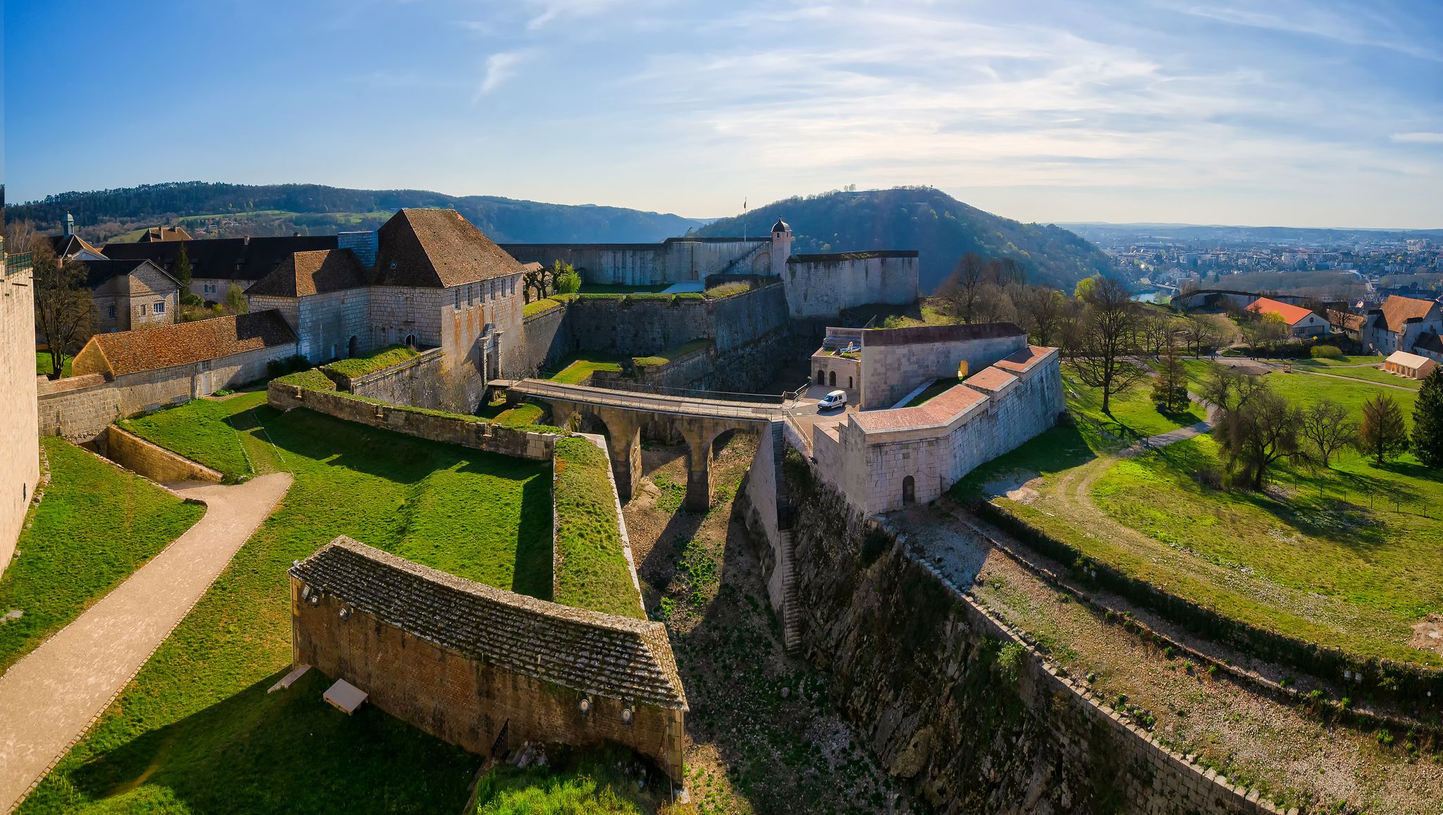 Top view of the entrance to the citadel from the city of Besancon. France. There are numerous defenses and a mountain landscape. Visible part of the city.