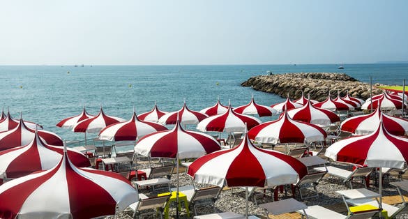 Cagnes-sur-Mer (Alpes-Maritimes, Provence-Alpes-Cote d'Azur, France), red and white umbrellas on the beach